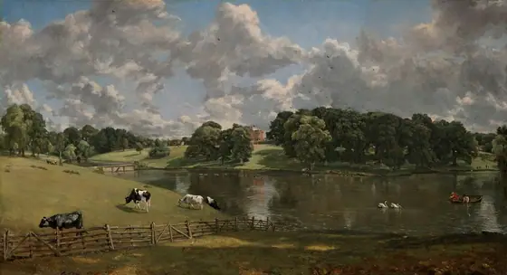 We look out onto a landscape with low, grassy hills to the left, a lake to the right, and a brick building in the center distance below a sky filled with towering white clouds in this horizontal painting.