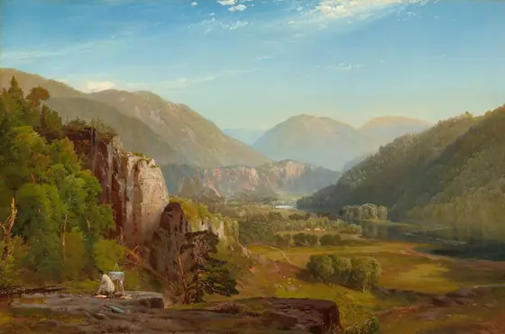 Far below us, a river winds through a valley lined with hazy mountains in this horizontal landscape painting.