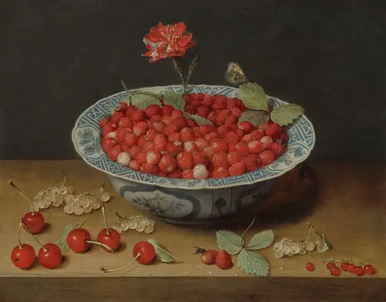 A blue and white bowl with a flaring rim is filled with small red strawberries, and the currants and cherries scattered around it are arranged along a wooden ledge or table in this horizontal still life painting.