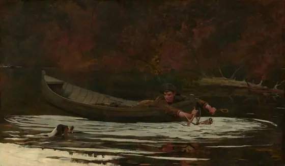 A young man with a peachy, ruddy complexion lies on his stomach in a wooden rowboat on a river, reaching forward to grasp the horn of a stag almost completely submerged in the rippling water with one hand.