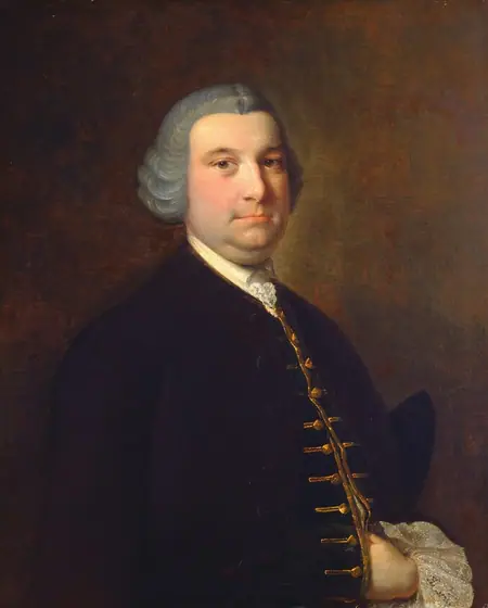 The image shows a portrait of a man with a soft, round face, a slightly double chin, small eyes, and a neutral expression. He has gray, voluminous hair styled in the fashion of the 18th century.