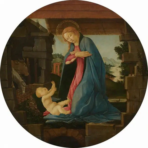 A woman kneels, angled to our left, and tips her face down toward a naked baby propped on a pillow against a pile of hay in a shed-like structure in this round painting.