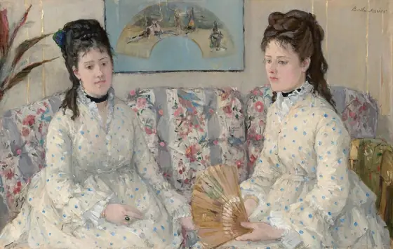 Shown from the lap up, two women with pale skin and dark hair pulled up and back, wearing white dresses with baby-blue polka dots, sit on a couch in this horizontal portrait painting.