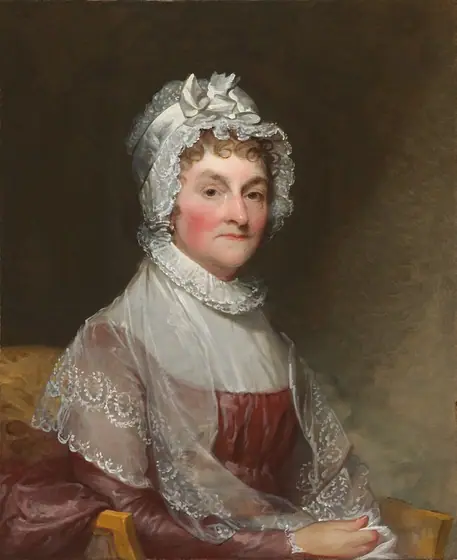 Shown from the hips up, a light-skinned woman with deeply flushed cheeks sits in an armchair, looking at us from under raised and pointed eyebrows in this vertical portrait painting.