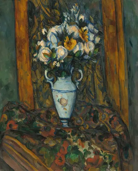 A vase holding mostly white flowers sits on a floral-patterned cloth in this vertical still life painting. The ice-blue vase has a narrow foot, tall, slightly tapering sides, round shoulders, and a long neck flanked by handles.
