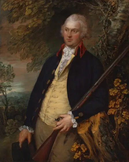 The image shows a man in a portrait from the waist up. He has fair skin, curly light-colored hair, and wears a dark navy coat with gold buttons and a vibrant red collar.