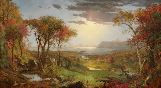 We look out onto a sweeping, panoramic view with trees, their leaves fiery orange and red, framing a view of a distant body of water under a sun-streaked sky in this long, horizontal landscape painting.