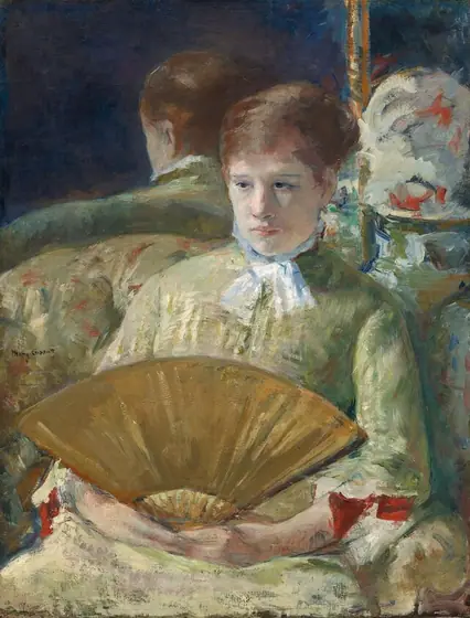 Shown from the hips up, a pale-skinned woman holds an open, gold-colored fan in her lap in this vertical, loosely painted portrait.