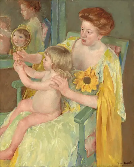 We look slightly down onto a woman dressed in golden yellows, sitting in a pale green chair, with a nude child sitting in her lap as they both gaze into a mirror in this vertical portrait painting. Both the people have pale, peachy skin.