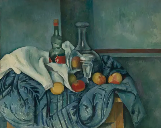 A glass bottle, a glass carafe, a stemmed glass, several pieces of fruit, and white and blue cloths are arranged on a wooden table in this horizontal still life. The bottle and carafe are at the center of this composition.