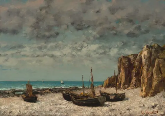 Four boats with low masts sit on a sandy beach next to rocky cliffs under a cloud-filled sky in this horizontal landscape painting. Three of the boats are clustered together near the center of the composition.
