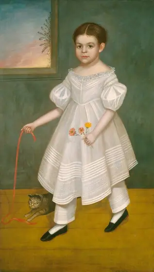 The image shows a full-body portrait of a young child standing indoors. The child faces forward with a neutral expression, looking directly at the viewer. They have neatly styled brown hair parted in the middle.
