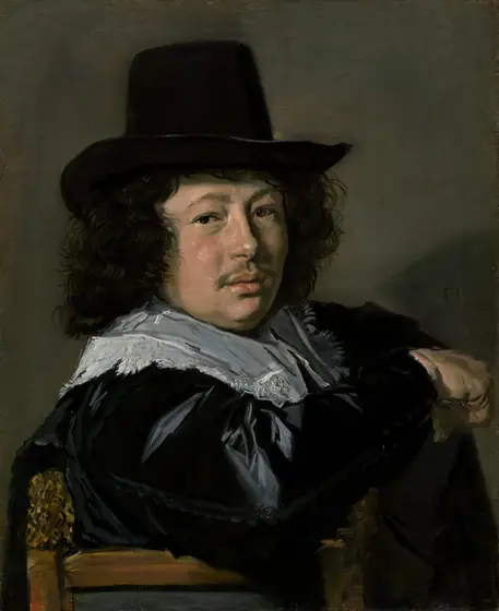 Shown from the chest up, a young man with a plump, pale-skinned face hooks one elbow over the back of a wooden chair and looks at us in this vertical portrait painting.